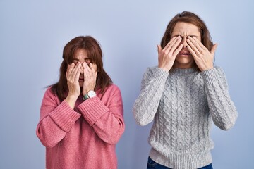 Poster - Mother and daughter standing over blue background rubbing eyes for fatigue and headache, sleepy and tired expression. vision problem