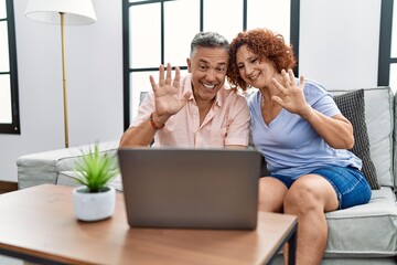 Poster - Middle age man and woman couple using laptop having video call sitting on sofa at home