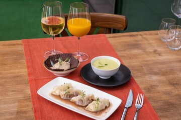 Sticker - Closeup a laid table with stuffed dumplings, fennel soup and hummus served with glasses of juice