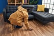 © Krakenimages.com - Young african american man looking for something under sofa at home