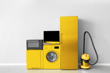 Wall Mural - Different yellow household appliances near light wall