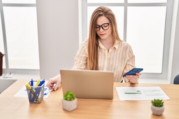 Poster - Young blonde woman business worker using laptop and smartphone at office