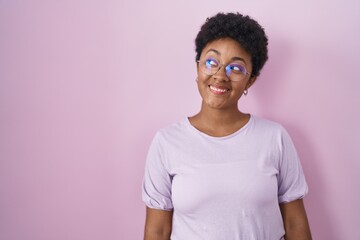 Poster - Young african american woman standing over pink background smiling looking to the side and staring away thinking.