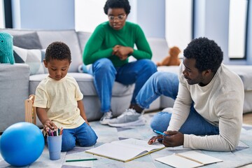 Sticker - African american family drawing on notebook sitting on floor at home