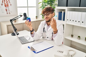 Sticker - Young arab man wearing doctor uniform choosing respiratory treatment at clinic