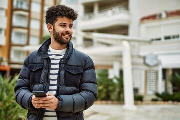 Canvas Print - Young arab man using smartphone outdoor at the town