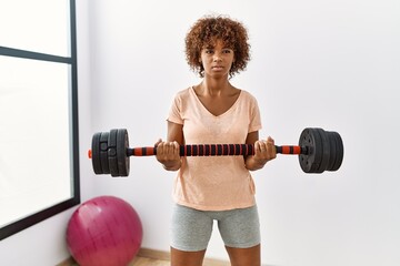 Sticker - Young african american woman training using dumbbell at sport center