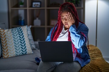 Sticker - African american woman with braided hair using computer laptop at night yawning tired covering half face, eye and mouth with hand. face hurts in pain.