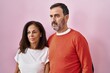 © Krakenimages.com - Middle age man and woman couples standing together with relaxed expression over pink background