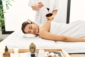 Sticker - Young latin woman relaxed having back massage with chocolate therapy at beauty center