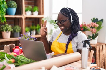 Sticker - Young african woman working at florist shop doing video call doing ok sign with fingers, smiling friendly gesturing excellent symbol