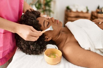 Sticker - Young african american woman having facial treatment at beauty center