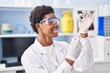 © Krakenimages.com - African american woman wearing scientist uniform holding vaccine at laboratory