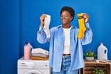 African american woman holding clean andy dirty socks smiling and laughing hard out loud because funny crazy joke.