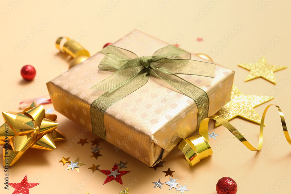 Gift box with Christmas decor on beige background, closeup