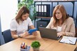 © Krakenimages.com - Mother and daughter business workers using laptop and touchpad working at office
