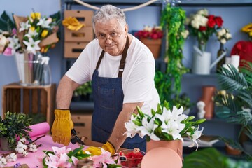 Canvas Print - Middle age grey-haired man florist cutting stem at florist