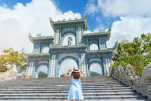 Woman Traveler Visiting At Linh Ung Pagoda Temple, Translation From Chinese Character. Tourist With Blue Dress And Hat Traveling In Da Nang City. Vietnam And Southeast Asia Travel Concept