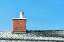 Red Chimney With Metal Vent And Gray Roof