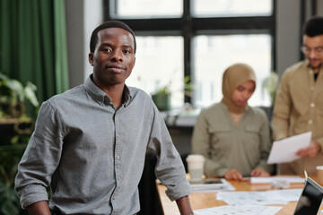 Aufkleber - Young confident African American business leader in smart casualwear standing in front of camera against two intercultural colleagues