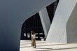 Woman standing in geometric modern architecture urban space
