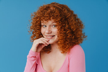 White ginger woman with curly hair smiling and looking at camera