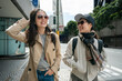 © PR Image Factory - two smiling asian chinese female coworkers chatting happily on pedestrian walk while walking to work together in san Francisco California usa.