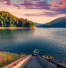 Summer Sunset On Dragan Lake With Staircase And Fishing Boat. Fantastic Morning View Of Apuseni Natural Park. Picturesque Landscape Of Romania, Europe. Traveling Concept Background.