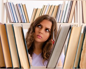 Young female student preparing for exams at library