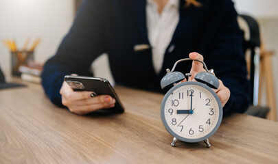 Wall Mural - alarm clock on the desk. business working in modern office building or home at night using laptop..