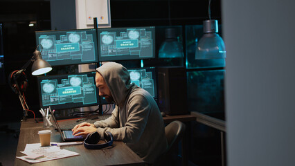 Dangerous IT coder working on security breach, creating cyber attack on data server. Hacking computer system and software, breaking database security and stealing program information. Handheld shot.