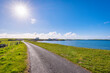 © Westend61 - UK, Scotland, Melby, Sun shining over empty coastal road