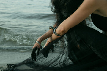 Poster - Lady in sitting nearby ocean scenic photography. Conceptual image. Seacoast. Picture of woman with seashore on background. High quality wallpaper. Photo concept for ads, travel blog, magazine, article