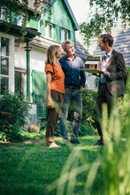 Mature Couple Discussing With Real Estate Agent In Backyard