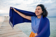Happy Woman Wrapping Scarf Amidst Sea