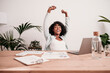 © Westend61 - Happy businesswoman with arms raised at desk in home office