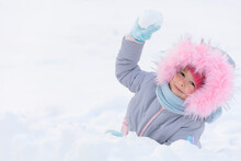 Kid Playing With Snowballs In Fortress. Little Cute Ruddy Girl With Red Cheeks Throwing Snow, Building Snowman. Family Christmas Vacation With Child Frosty Winter Park. Wintertime, Active Game Outdoor