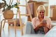 © bernardbodo - Happy woman using mobile phone in new home. .