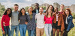 © Lomb - Large group of multiethnic friends posing together hugging outdoors smiling and looking at camera