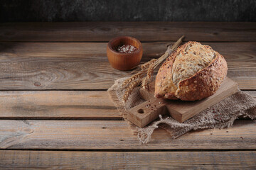 Wall Mural - Fresh baked whole grain bread with oats, flax seeds and sesame seeds on rustic wooden board. Bakery products