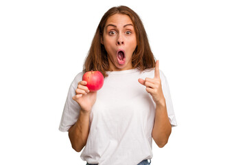 Young caucasian woman holding a red apple isolated having an idea, inspiration concept.