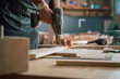 © Prins Productions - Male carpenter doing woodwork with electric machinery close up