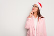© Asier - Business caucasian woman wearing a christmas hat isolated on white background looking sideways with doubtful and skeptical expression.