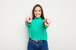 © Asier - Young caucasian cute woman isolated on white background cheerful smiles pointing to front.