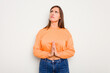 © Asier - Young caucasian cute woman isolated on white background holding hands in pray near mouth, feels confident.