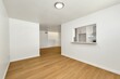 Wide corridor with white walls, kitchen view and wooden floor, brand new house interior