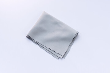 Microfiber cleaning cloth for glasses, eyeglass or camera lens isolated on white background. Grey micro fibre cloth.