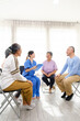 © artitwpd - The caregiver therapist sits with a group of Asian senior people in a circle for checking physical and mental health in a group elderly therapy session. The nursing home concept. Vertical image.