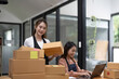 © Natee Meepian - Two Asian woman working together for SME project. Young Owner people startup for Business Online, SME, Delivery Project. Online Business and Small business Concept