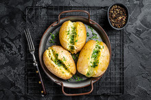 Baked Jacket Potatoes With Cheese, Herbs And Butter. Black Background. Top View